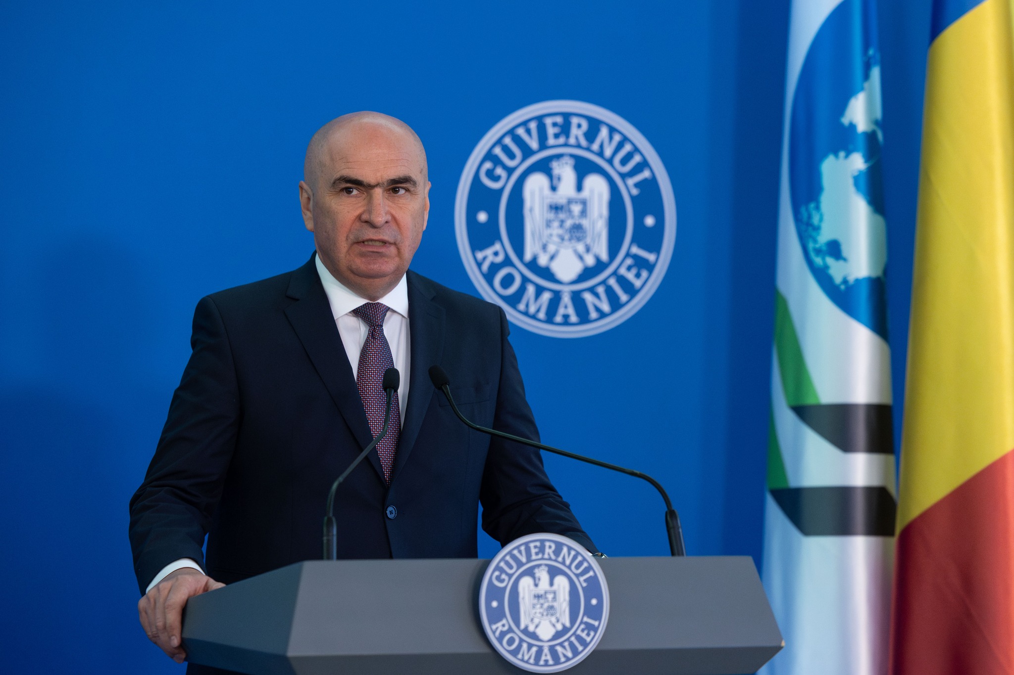 Bolojan afirmă: Este necesar să inițiem procesul de listare pe bursă pentru pachetele minoritare de acțiuni ale companiilor de stat, menținând totuși controlul; cazuri recente de listări includ CEC și Aeroportul Otopeni.