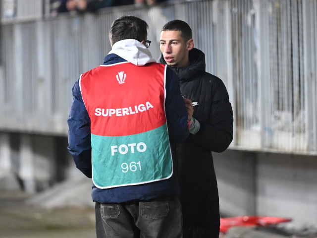 Un fotbalist așteaptă sfârșitul meciului și apoi se confruntă agresiv cu un fotograf, distrugându-i dispozitivul electronic portabil. Conversația tensionată între cei doi