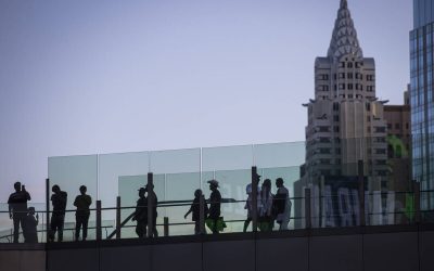People cross a pedestrian bridge along the Las Vegas Strip during Labor Day weekend on Sunday, ...
