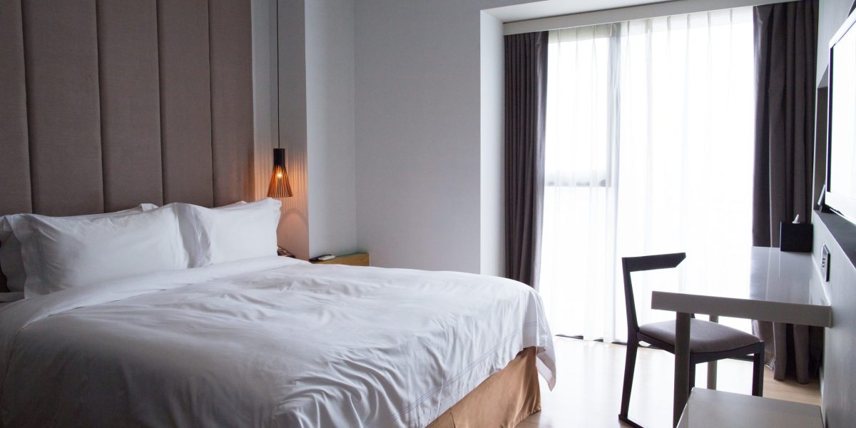 hotel-bedroom-with-double-bed-table-tv-set-scaled.jpg - JurnalUrban